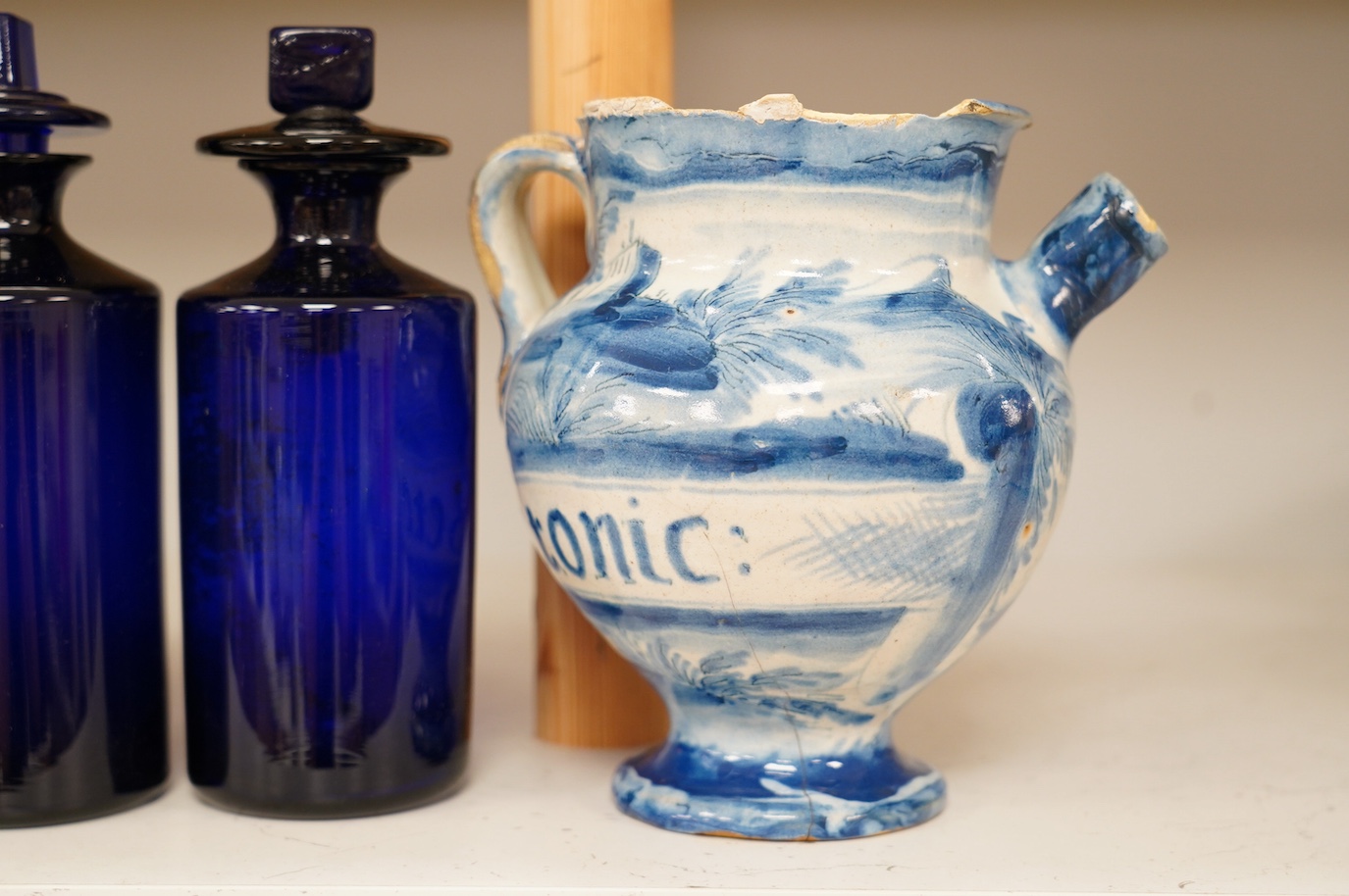 An 18th century pearlware mug, an 18th century Italian maiolica wet drug jar, a faceted wine glass, a commemorative jug and a pair of Bristol blue glass decanters and stoppers, tallest 19cm. Condition - varies